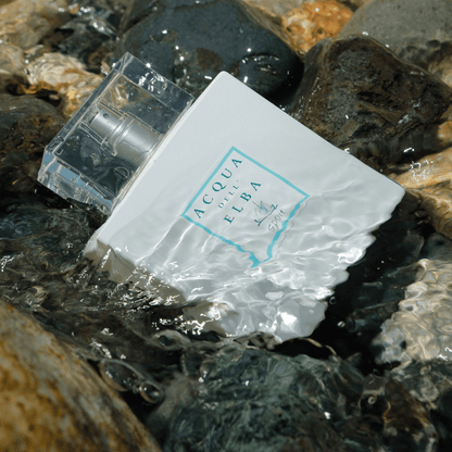Acqua dell’Elba Sport immerso nell’acqua tra pietre scure
