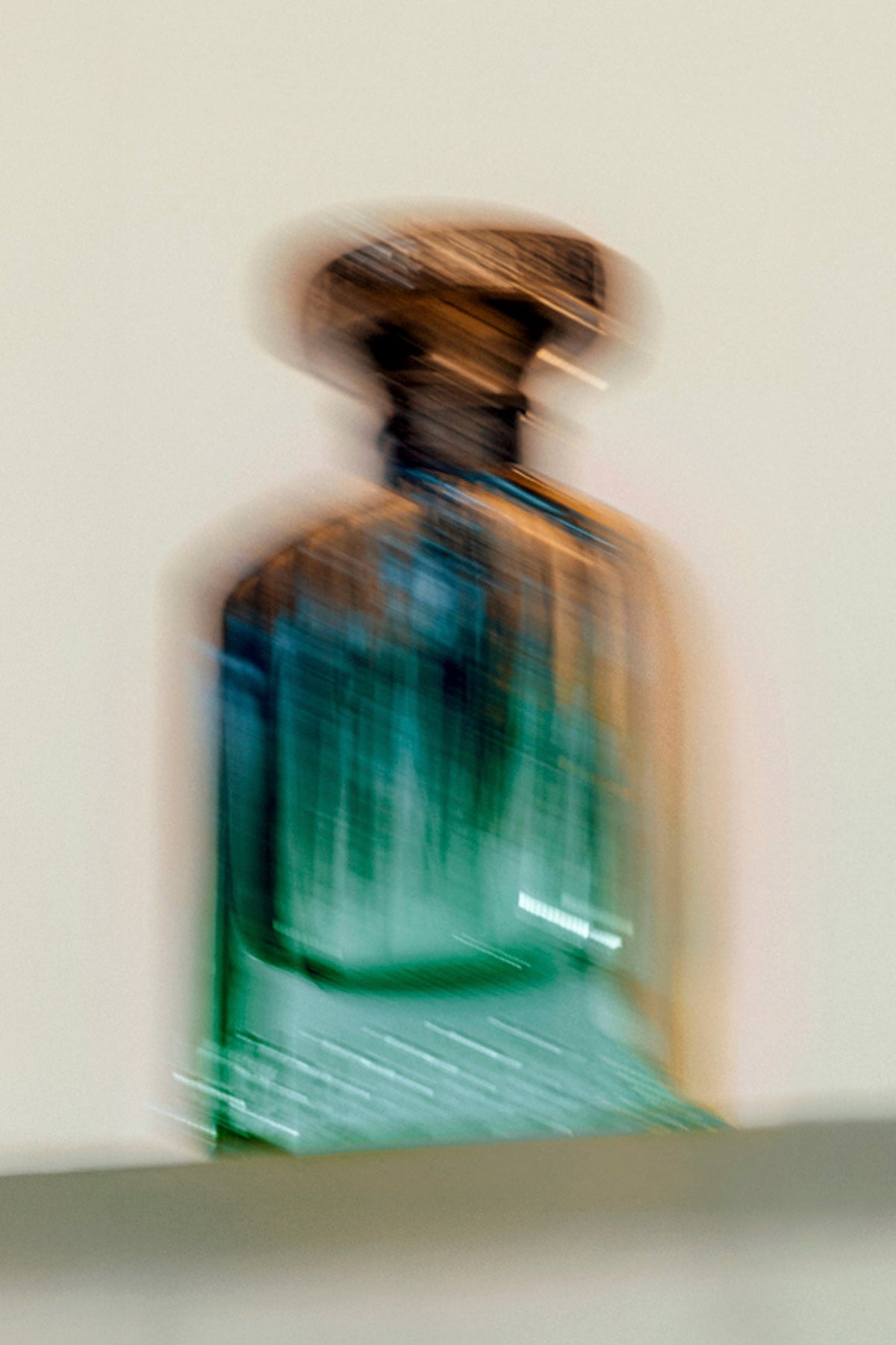 ANFAS JANNAH — scatto artistico del flacone verde in movimento; fotografia ufficiale ANFAS