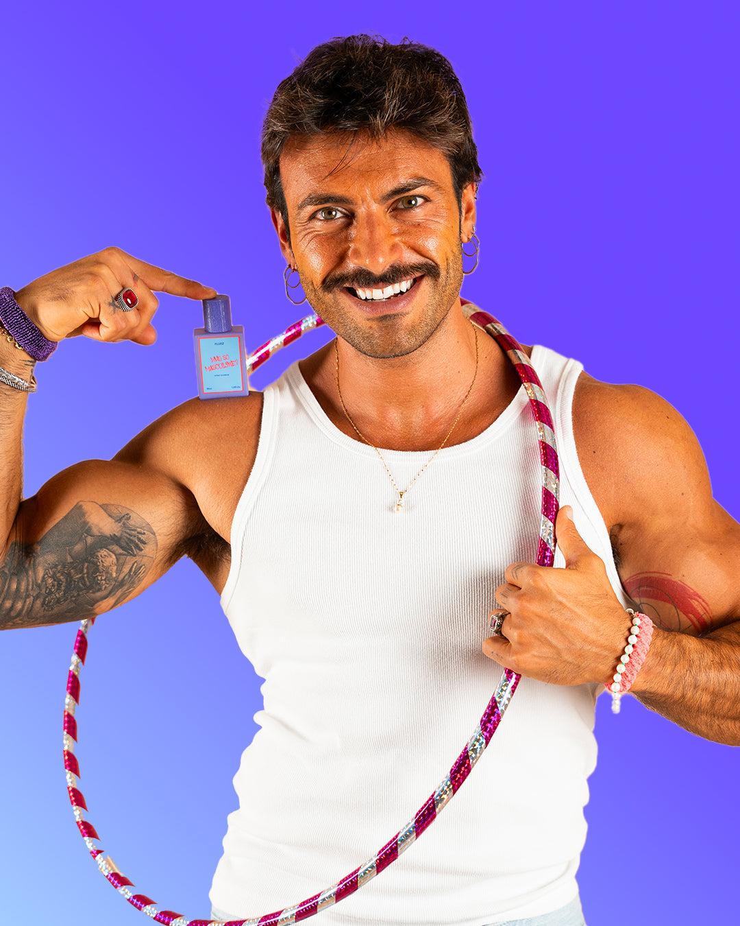 Modello in canotta bianca mostra il flacone viola di Fluez Why So Masculine?