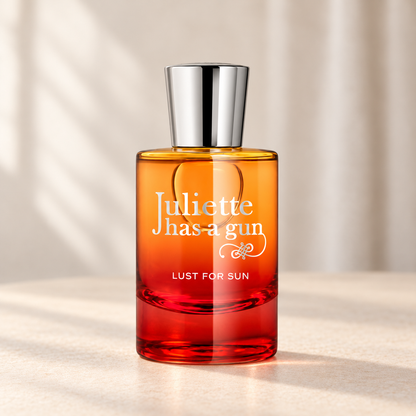 LUST FOR SUN di Juliette Has a Gun — flacone frontale su fondo beige, ambientazione creata con IA